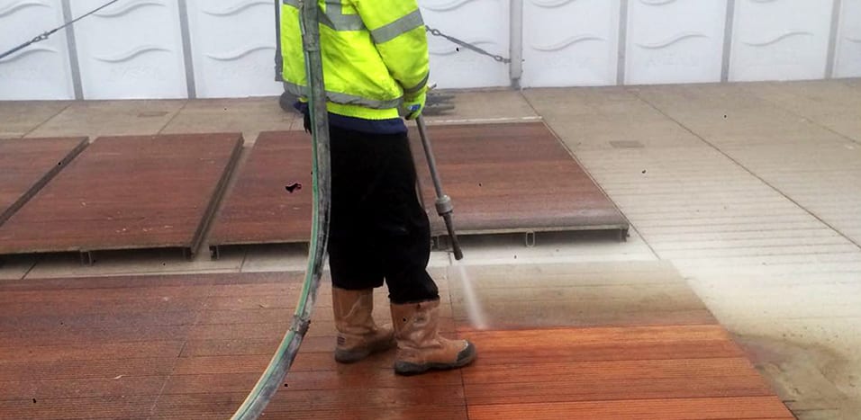 male contractor shot blasting wooden floor